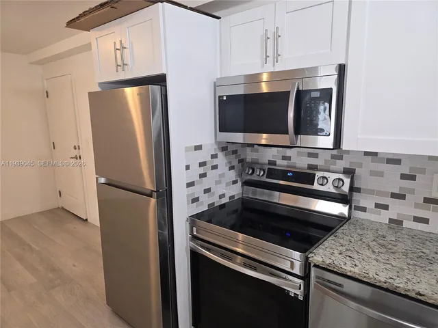 a kitchen with stainless steel appliances granite countertop a refrigerator stove and microwave