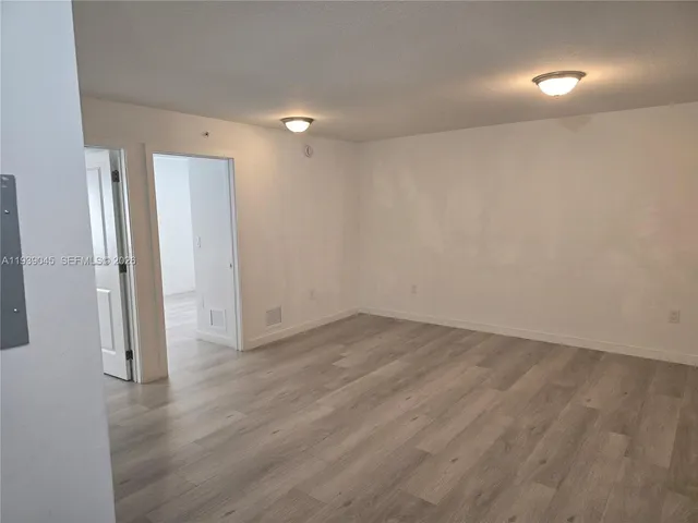 an empty room with wooden floor and a window