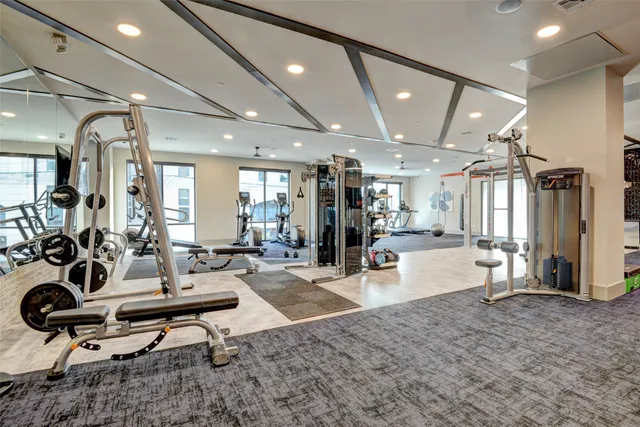 a living room with furniture a rug and gym equipment