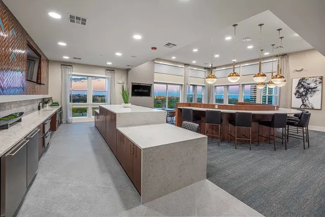 a large kitchen with stainless steel appliances lots of counter space and furniture