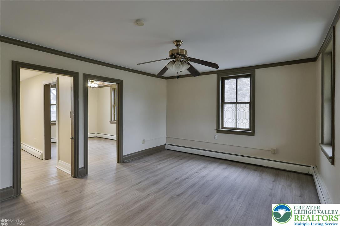 4448 Orefield Road Orefield, PA 18069 - Photo 15 of 20 an empty room with wooden floor chandelier and windows
