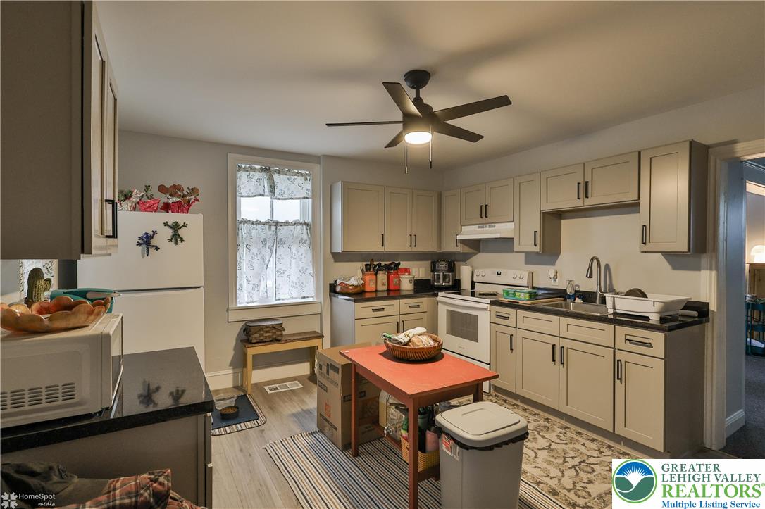 4448 Orefield Road Orefield, PA 18069 - Photo 6 of 20 a kitchen with a sink stove and cabinets