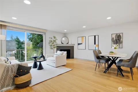 a living room with furniture a fireplace and a large window
