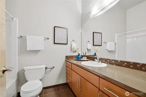 a bathroom with a granite countertop sink a large mirror and toilet