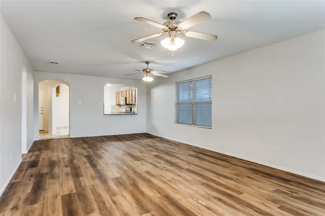 a view of an empty room with a chandelier fan