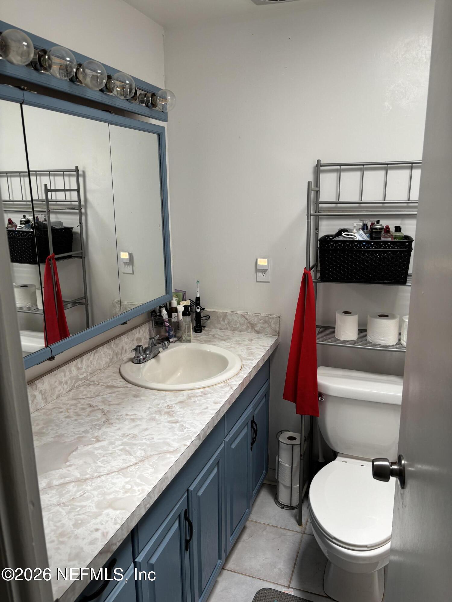 918 Bacall Road Jacksonville, FL 32218 - Photo 4 of 12 a bathroom with a granite countertop sink a toilet and a mirror