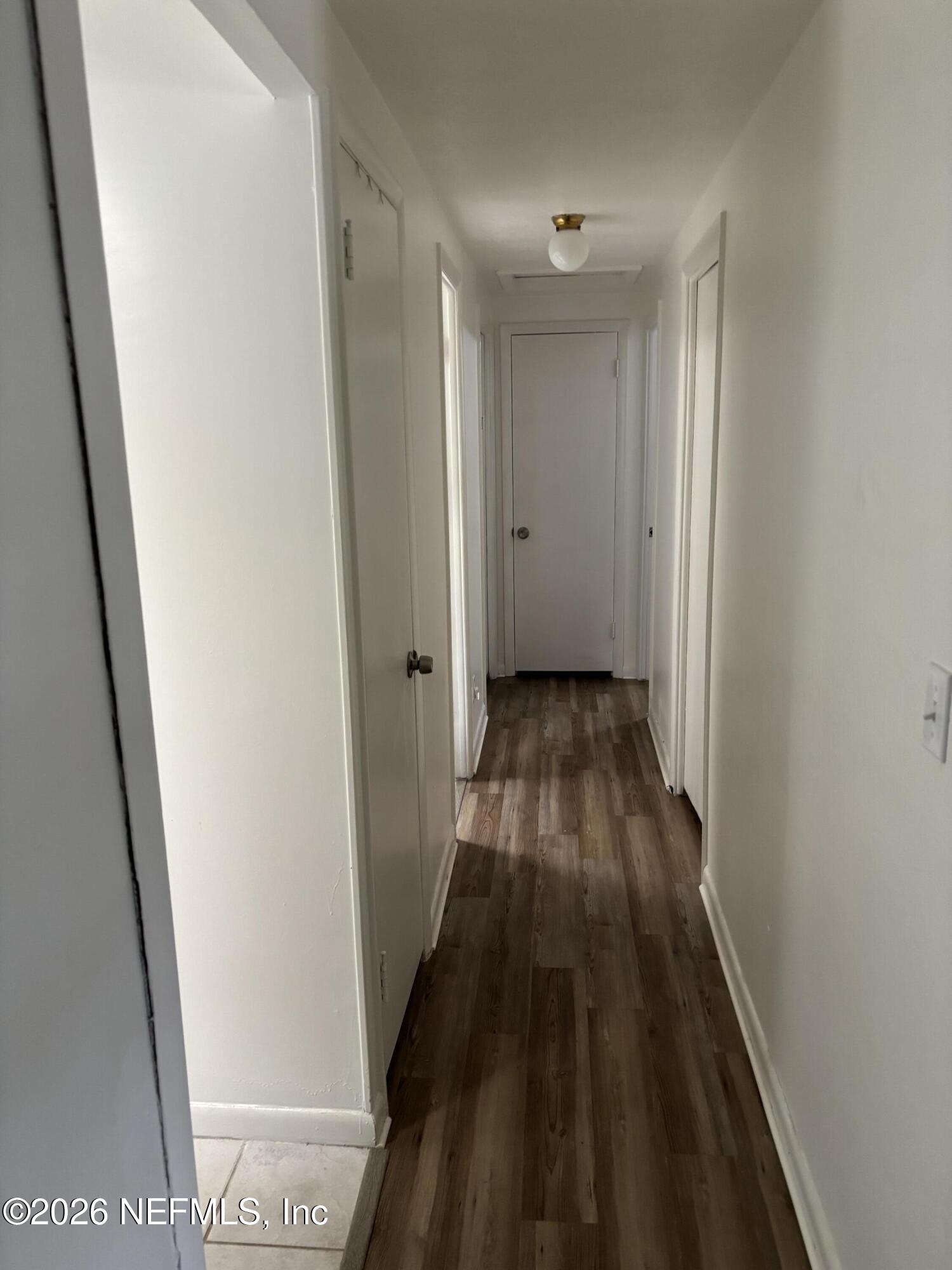 918 Bacall Road Jacksonville, FL 32218 - Photo 6 of 12 a view of a hallway with wooden floor and a bathroom