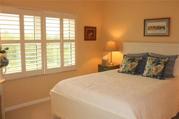 a large bed sitting in a bedroom next to a window