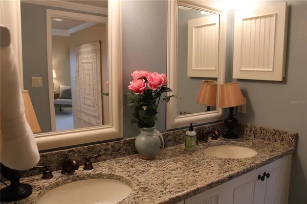 a bathroom with a granite countertop sink and a mirror