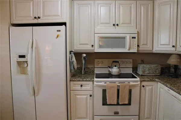a kitchen with stainless steel appliances granite countertop a refrigerator and a stove