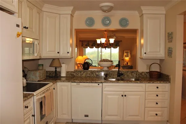 a kitchen with stainless steel appliances granite countertop a sink a stove and cabinets