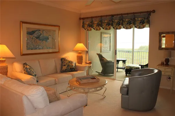 a living room with furniture a large window and a flat screen tv
