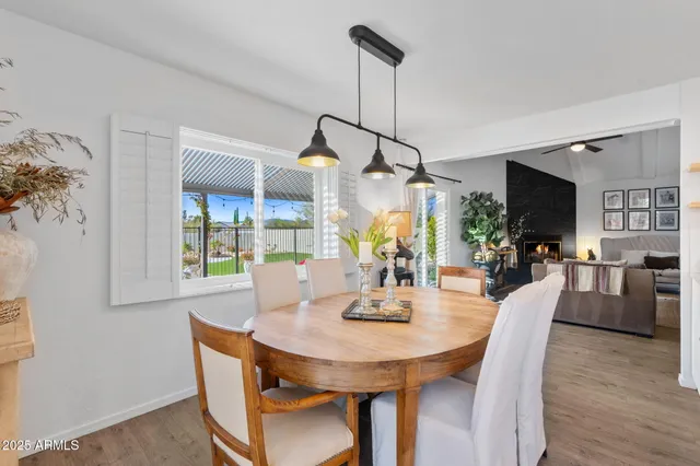 a view of a dining room and livingroom with furniture wooden floor a chandelier