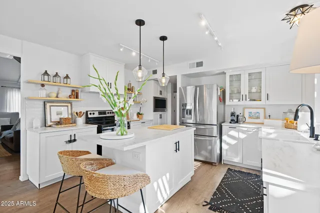 a kitchen with stainless steel appliances granite countertop sink stove and refrigerator