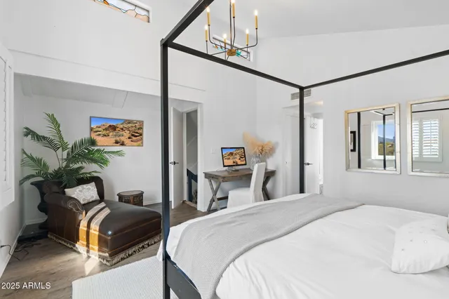 a bedroom with a bed and a chandelier