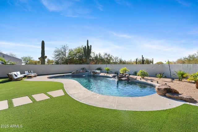 a view of a swimming pool with lawn chairs and couches