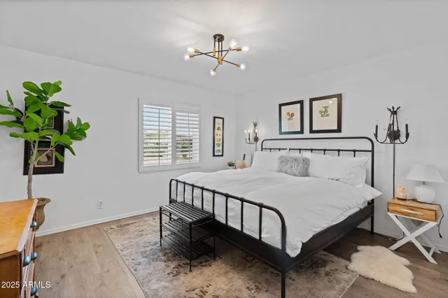 a bedroom with a bed table and a window