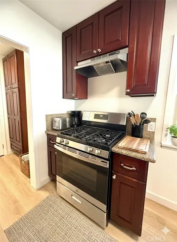 a kitchen with stainless steel appliances granite countertop wooden cabinets and a stove top oven