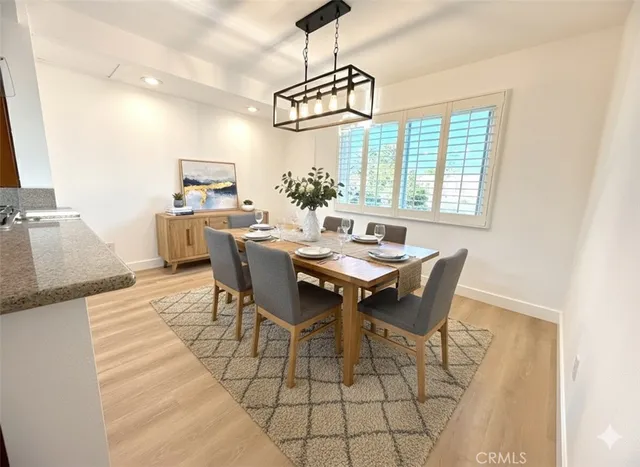 a dining room with furniture a chandelier and wooden floor