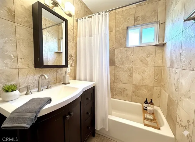 a bathroom with a granite countertop sink and a bathtub