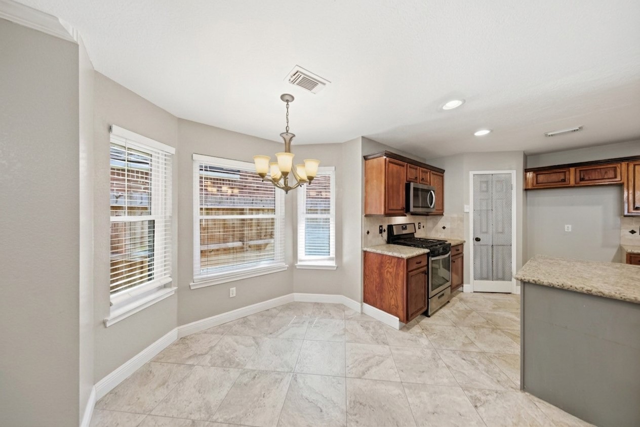 13506 Spring Court Tomball, TX 77375 - Photo 8 of 37 a large kitchen with granite countertop a stove and a sink