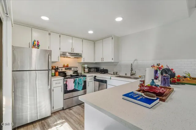 a kitchen with refrigerator and white cabinets