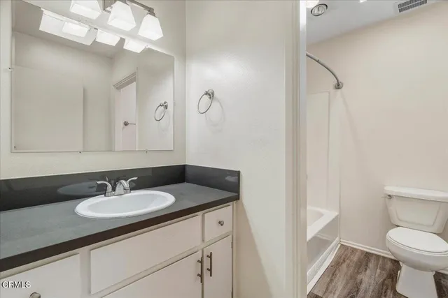 a bathroom with a sink a toilet and a mirror