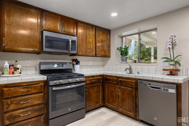 a kitchen with stainless steel appliances kitchen island granite countertop a stove a sink and a microwave