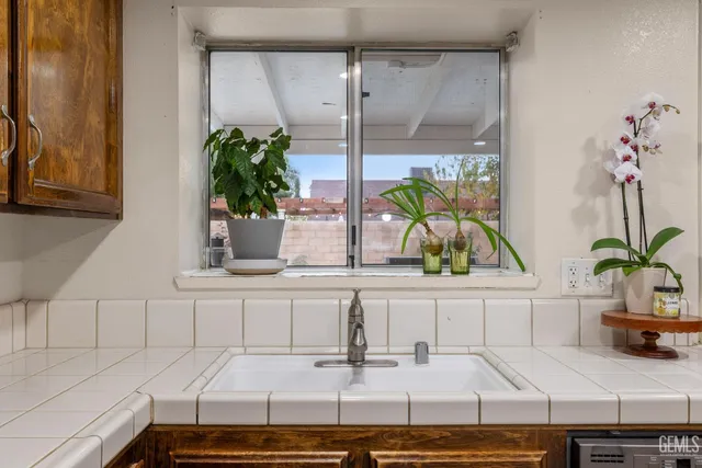 a kitchen with stainless steel appliances granite countertop a refrigerator a stove a sink a dining table and chairs with wooden floor