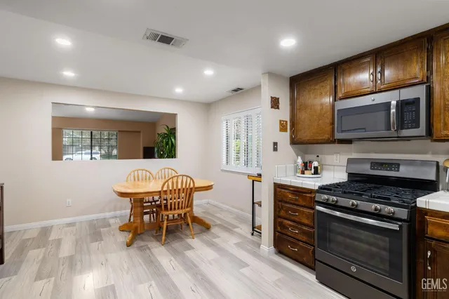 a kitchen with stainless steel appliances granite countertop refrigerator sink and cabinets
