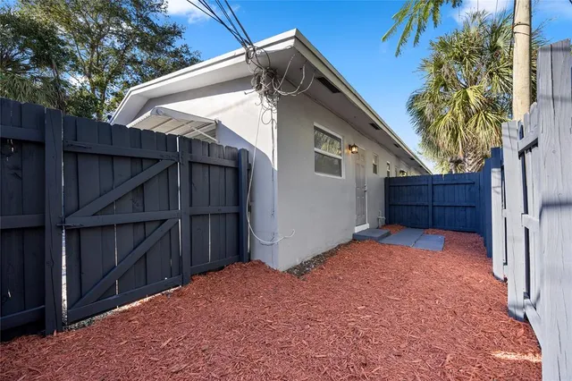 a view of backyard with small cabin and wooden fence