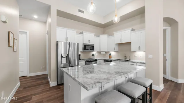 a kitchen with stainless steel appliances granite countertop a sink refrigerator and cabinets