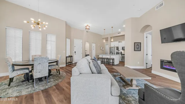 a living room with furniture kitchen view and a large window