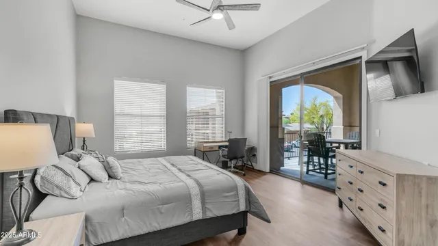 a bedroom with a bed a table and flat screen tv