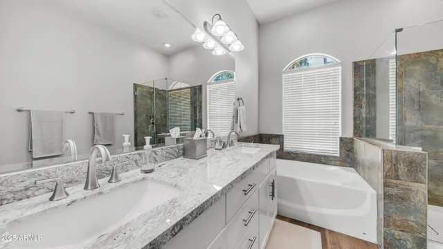 a bathroom with a granite countertop sink a large mirror and a shower
