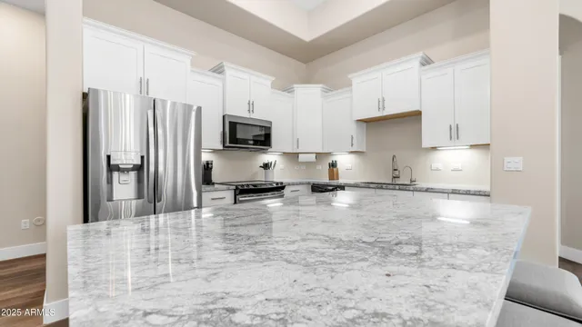 a kitchen with kitchen island a counter top space a sink stainless steel appliances and cabinets