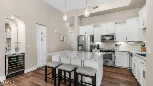 a kitchen with stainless steel appliances a stove a sink island and a refrigerator