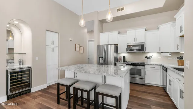 a kitchen with stainless steel appliances a stove a sink island and a refrigerator