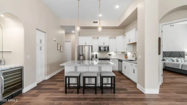 a view of a dining room and livingroom with furniture wooden floor a chandelier