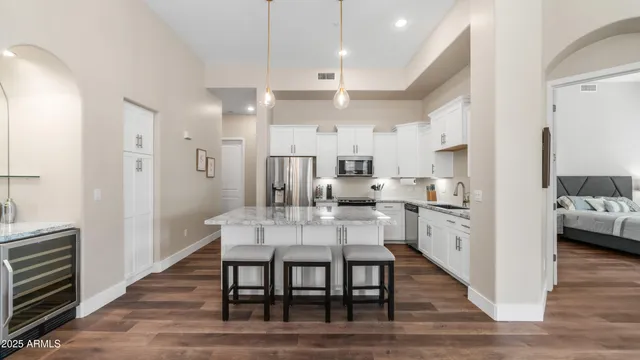 a view of a dining room and livingroom with furniture wooden floor a chandelier
