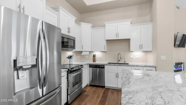 a kitchen with stainless steel appliances a refrigerator sink and stove