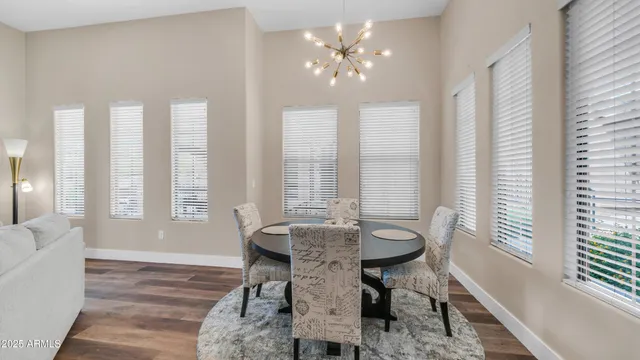a view of a dining room with furniture a chandelier and wooden floor