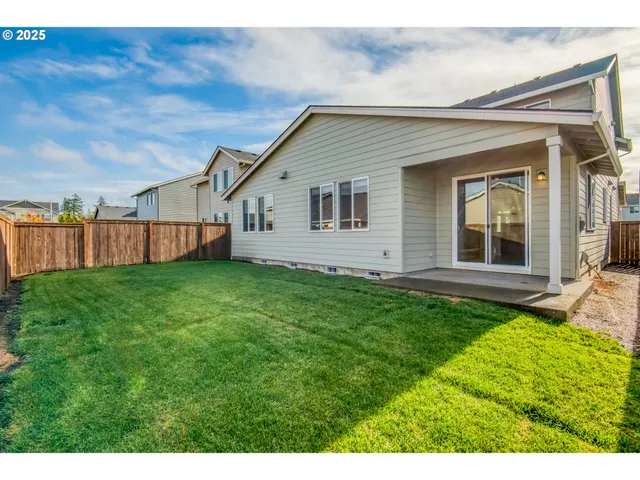 a view of yard with swimming pool and wooden fence