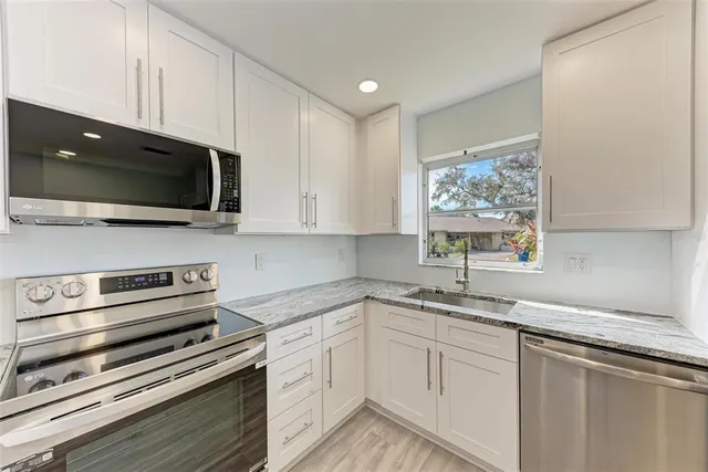 a kitchen with a sink stainless steel appliances and cabinets