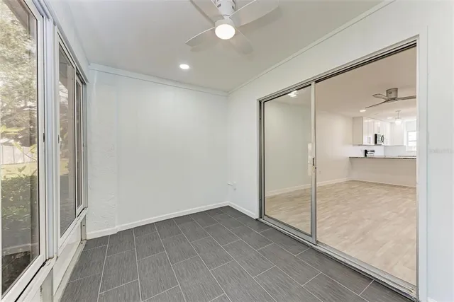 a view of empty room with wooden floor and fan