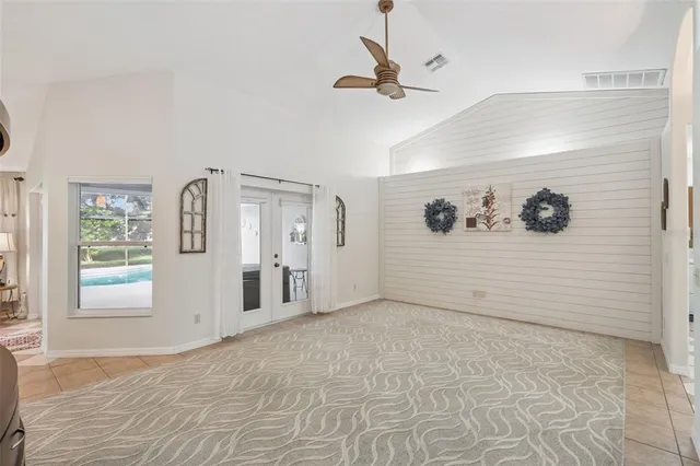 a large white kitchen with a large island stainless steel appliances a stove a sink a window and a counter top space