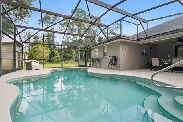 an aerial view of residential house with outdoor space and trees all around