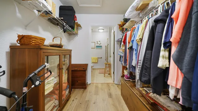 a view of walk in closet with clothes and shoes