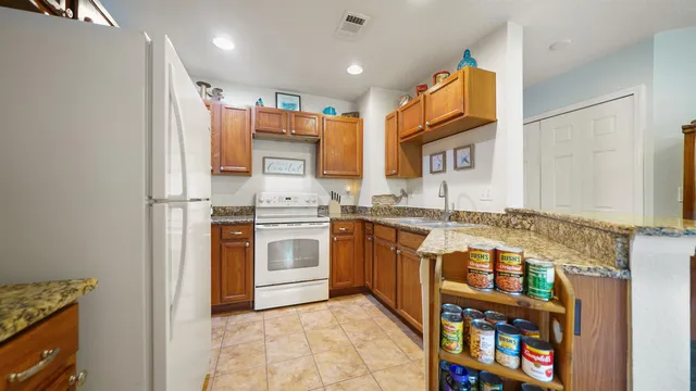 a kitchen with stainless steel appliances granite countertop a refrigerator and a stove top oven
