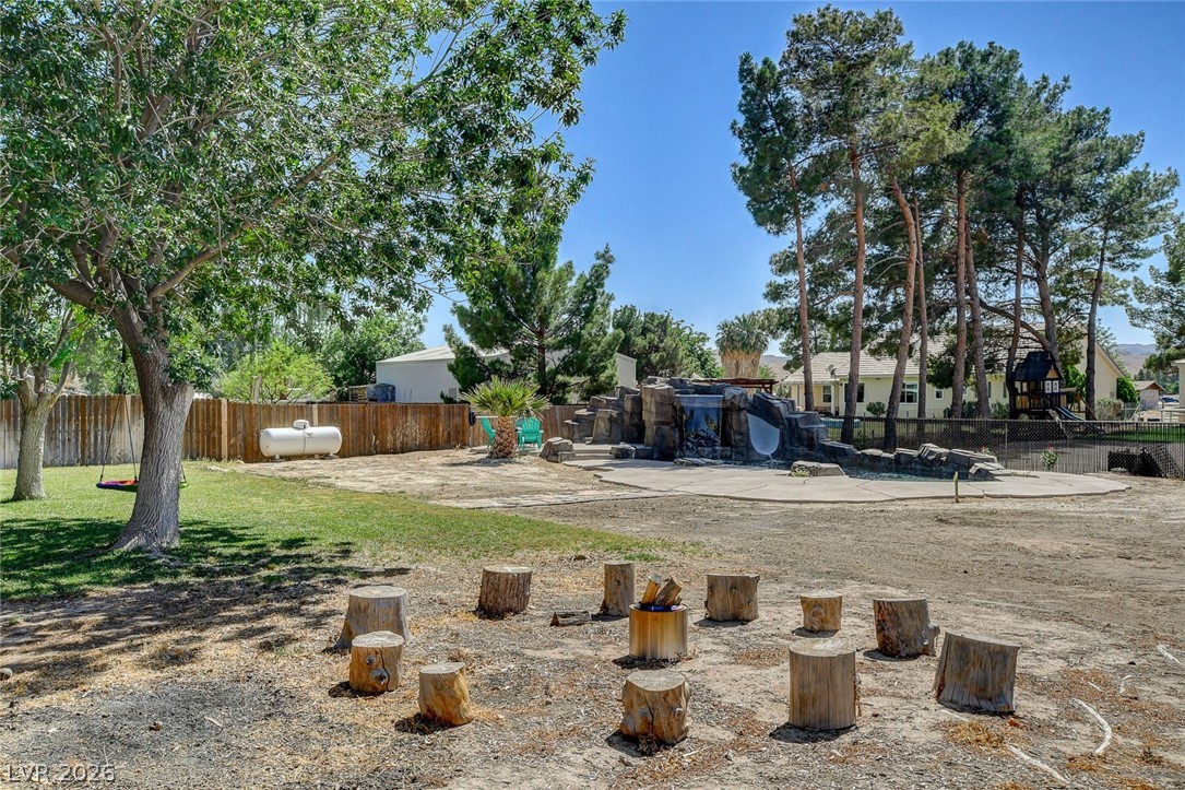 3765 Berkeley Street Logandale, NV 89021 - Photo 71 of 87 This spacious backyard features a unique fire pit, lush landscaping, and a refreshing swimming pool.